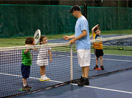 Tennis instructor teaching boys and girls